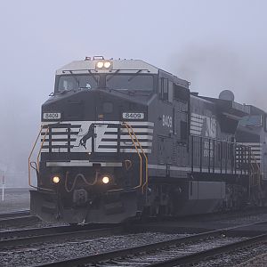 Still in the fog NS 8409 heads east passed the depot in Elkhart