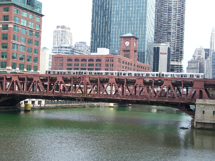 A CTA train crosses a green Chicago River