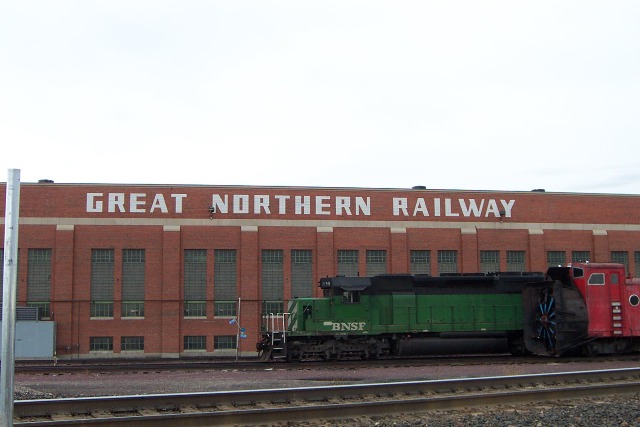 Rotary plow & SD40-2 in front of old G.N.R.Y. railroad building