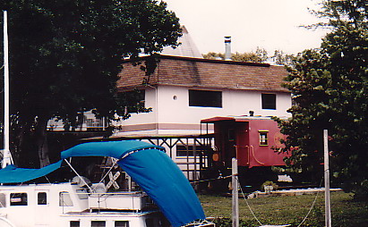 A caboose on final rest in a garden.